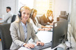 © Bojan - Young blonde female receptionist with headset in office