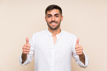 Wall Mural - Handsome man with beard over isolated background giving a thumbs up gesture