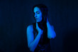© Alex - Studio portrait of a beautiful girl in a black dress in blue, colored lamps. beauty spoils on a dark background