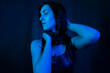 © Alex - Studio portrait of a beautiful girl in a black dress in blue, colored lamps. beauty spoils on a dark background