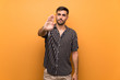 © luismolinero - Handsome man with beard over isolated background making stop gesture