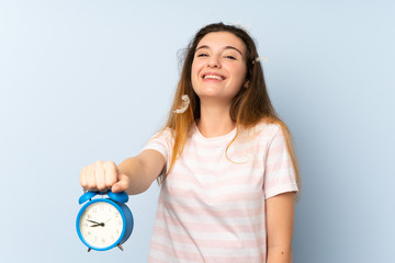 Young brunette girl holding vintage clock over isolated background