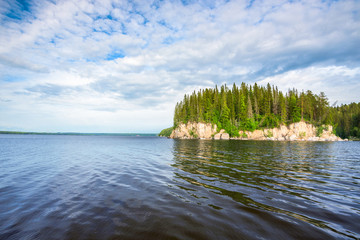 Wall Mural - Panoramic view of the rocky cliff near the river Kama, blue sky with white clouds.