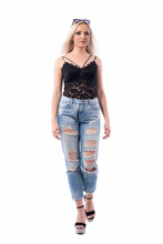 Stylish Casual Blonde Hair Girl In Trendy Ripped Jeans Walking And Looking Away. Full Body Isolated On White Background. 