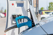 © michelmond - Electric car plugged in to charge battery at a charging station