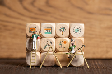 little painter figure is writing marketing symbols on wooden blocks