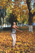 © Александр Юркевич - girl threw up yellow autumn leaves, orders and plays in the park, sunny day, smile, laugh and good mood