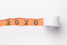 Date With Wooden Figure 2020 Under A Torn Strip Of White Cardboard, Numbers In Orange Hole Of Torn Paper, New Year Concept, Calendar Cover Design