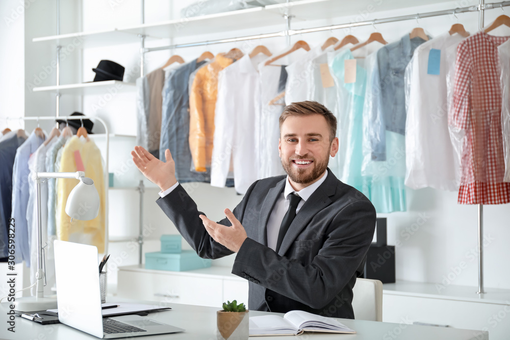 Male worker of modern dry-cleaner's at reception