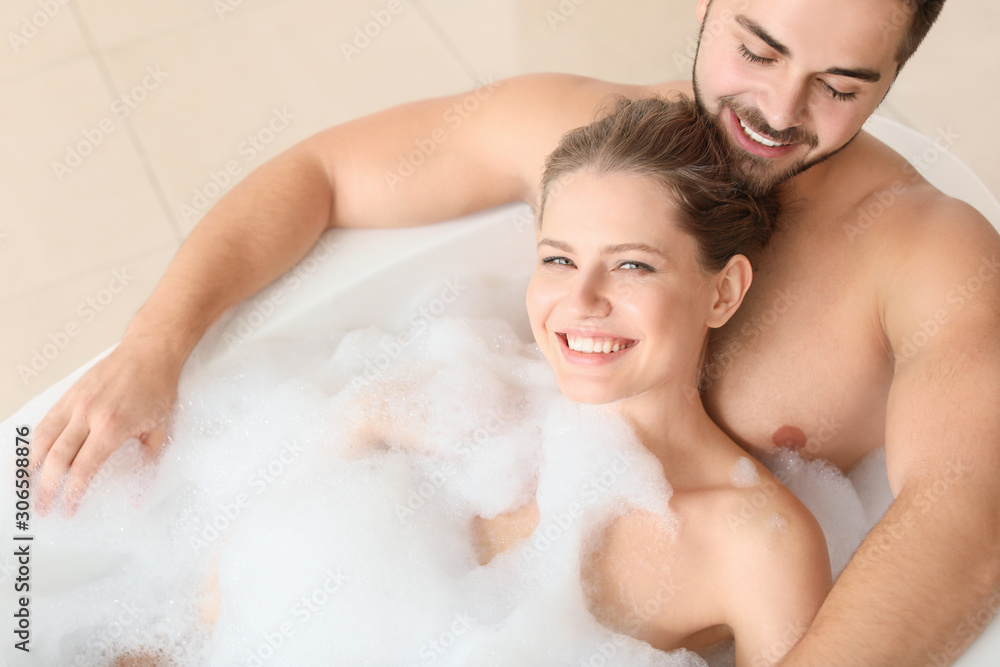 Happy young couple taking bath together