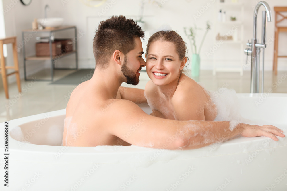 Happy young couple taking bath together