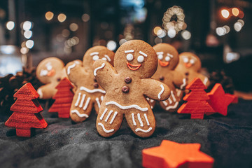 Many Christmas cookies in the form of gingerbread men depicting people celebrating the New Year in the forest near the Christmas tree