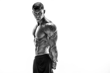 Wall Mural - Tattooed muscular super-high level handsome man posing in studio isolated on white background