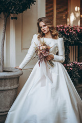 incredibly charming bride poses for a photo in a sophisticated wedding dress walking along the pretty streets of the old Georgian city of Tbilisi