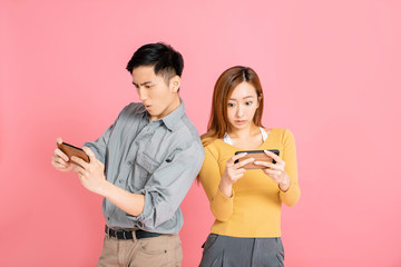 Wall Mural - Cheerful young couple watching and playing the smart phone