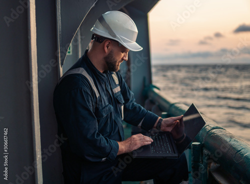 Fotomural Marine chief officer or captain on deck of vessel or ship watching laptop