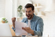 Excited man reading postal mail letter overjoyed by good news