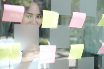 businesswoman woman thinking planning with adhesive notes on glass wall