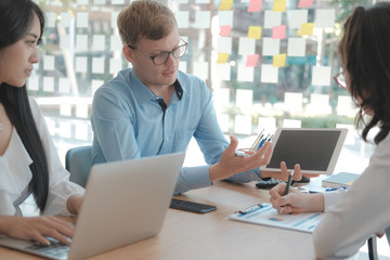 Wall Mural - business people discussing on performance revenue in meeting. businessman working with businesswoman.