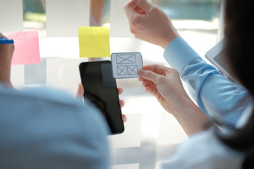 user experience UX designer designing web on smart phone layout. UI developer planning working on mobile application prototype