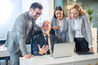 © Bojan - Group of business people having meeting with their experienced senior boss in modern office