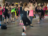 Fitness Workout in Gym: People doing Exercises in Class with Music and Teacher on Stage