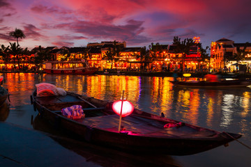 Wall Mural - Traditional boats in front of ancient architecture in Hoi An, Vietnam.