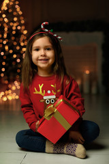 Poster - Cute little child with Christmas gift at home