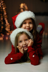 Poster - Cute little children wearing Santa hats at home. Christmas time