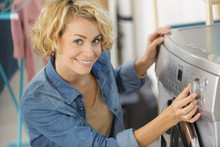 Woman Pressing Button Of Washing Machine For Laundry