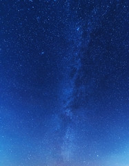 Wall Mural - a magical starry night on the river bank with a milky way in the sky and falling stars in the winter