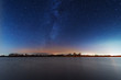 A magical starry night on the river bank with a milky way in the sky and falling stars in the winter.