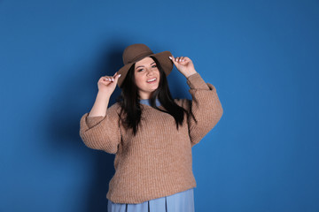 Beautiful overweight woman posing on blue background. Plus size model