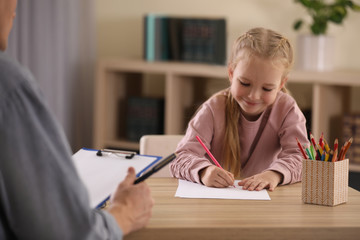 Wall Mural - Little girl on appointment with child psychotherapist indoors