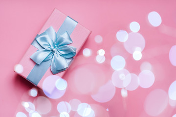 Wall Mural - Gift box with Blue ribbon on Pink background for copy space. Christmas minimal concept idea.