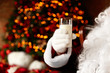 © New Africa - Santa Claus holding glass of milk against blurred Christmas lights, closeup