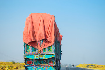 a heavy truck is overloaded and running too fast on a two way highway 