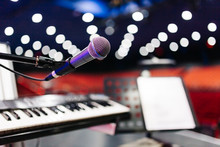 Microphone With Bokeh Background At Stage. (selective Focus) Behind The Photo There Is Keyboard And Music Stand