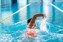 Professional Swimmer Doing Exercise In Indoor Swimming Pool