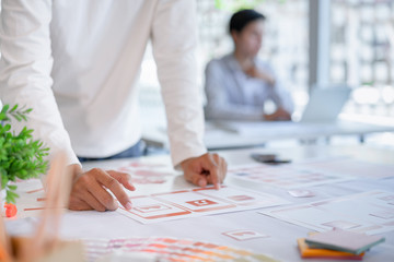 Cropped shot of creative UX UI designers team developing programming and coding mobile application from prototype and wireframe layout.