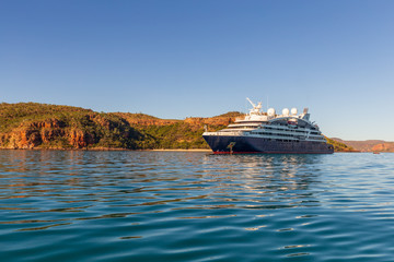 An luxury expedition cruise ship at anchor in the late afternoon in Prince Frederick Harbor on the remote North West Coast of the Kimberley Region of Western Australia.