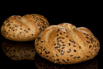 Group of two whole sesame kaiser roll isolated on black glass