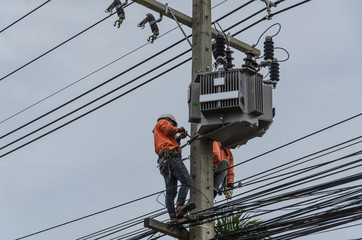 Technicians are repairing high voltage transmission systems on the power poles.