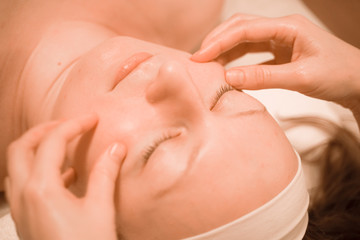 Wall Mural - Beautiful plus size middle age woman getting a face massage treatment at beauty salon. close up step by step