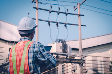 Electrical engineer holding and using a digital tablet