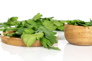 Wall Mural - Lot of whole lot of pieces of fresh green parsley on round bamboo coaster in bamboo bowl isolated on white background