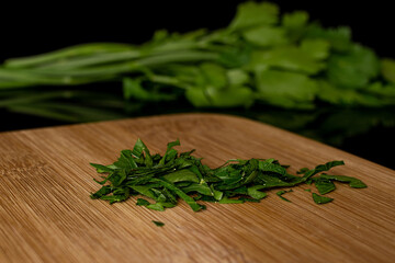 Wall Mural - Lot of whole lot of pieces of fresh green parsley on bamboo cutting board isolated on black glass