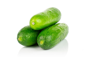 Group of three whole fresh green baby cucumber in pyramid isolated on white background