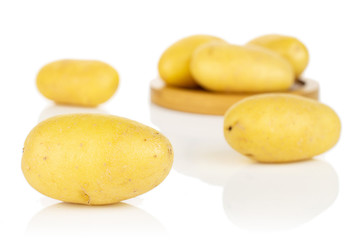 Wall Mural - Group of six whole pale yellow potato on bamboo coaster isolated on white background