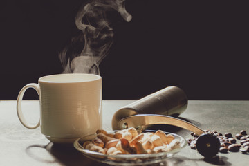 Wall Mural - The steam from a white cup of coffee with a coffee grinder and roasted peanuts on the old wood table and black background, Warm drinks make good healthy, Vintage style, Selective focus.